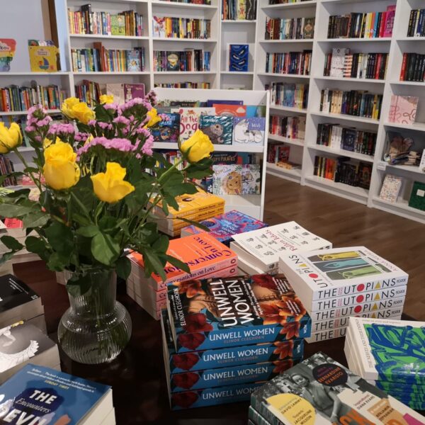 Books on a table with yellow roses