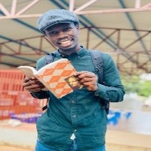 Mohan, a young, smiling black man, wears a cap and holds open a book