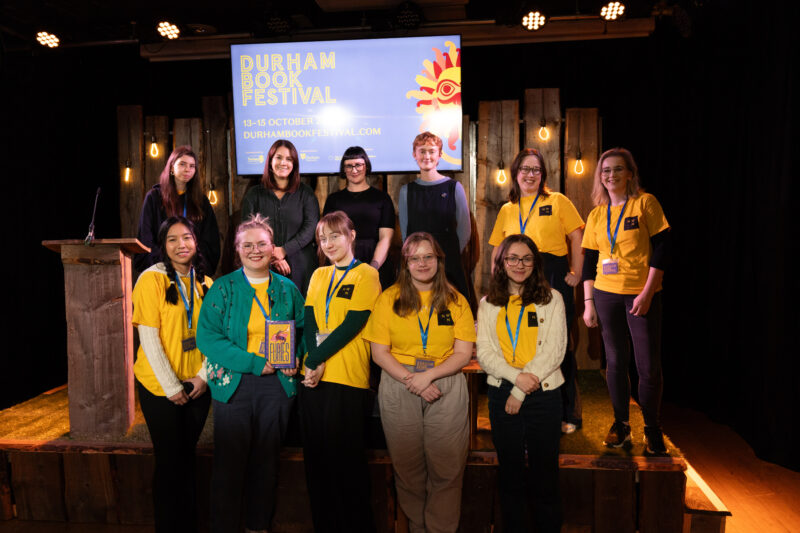 young programmers and event speakers pose on stage
